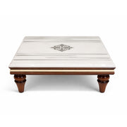 Square wooden table with a decorative center piece on a white background