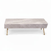 Aspire Coffee Table highlights a stone tabletop supported by thin gold legs.