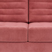 Close-up of a pink upholstered chair with a textured surface.