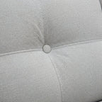 Close-up of a light gray cushion with a button on a textured fabric background