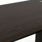 Close-up of a dark wooden desk surface with a white background