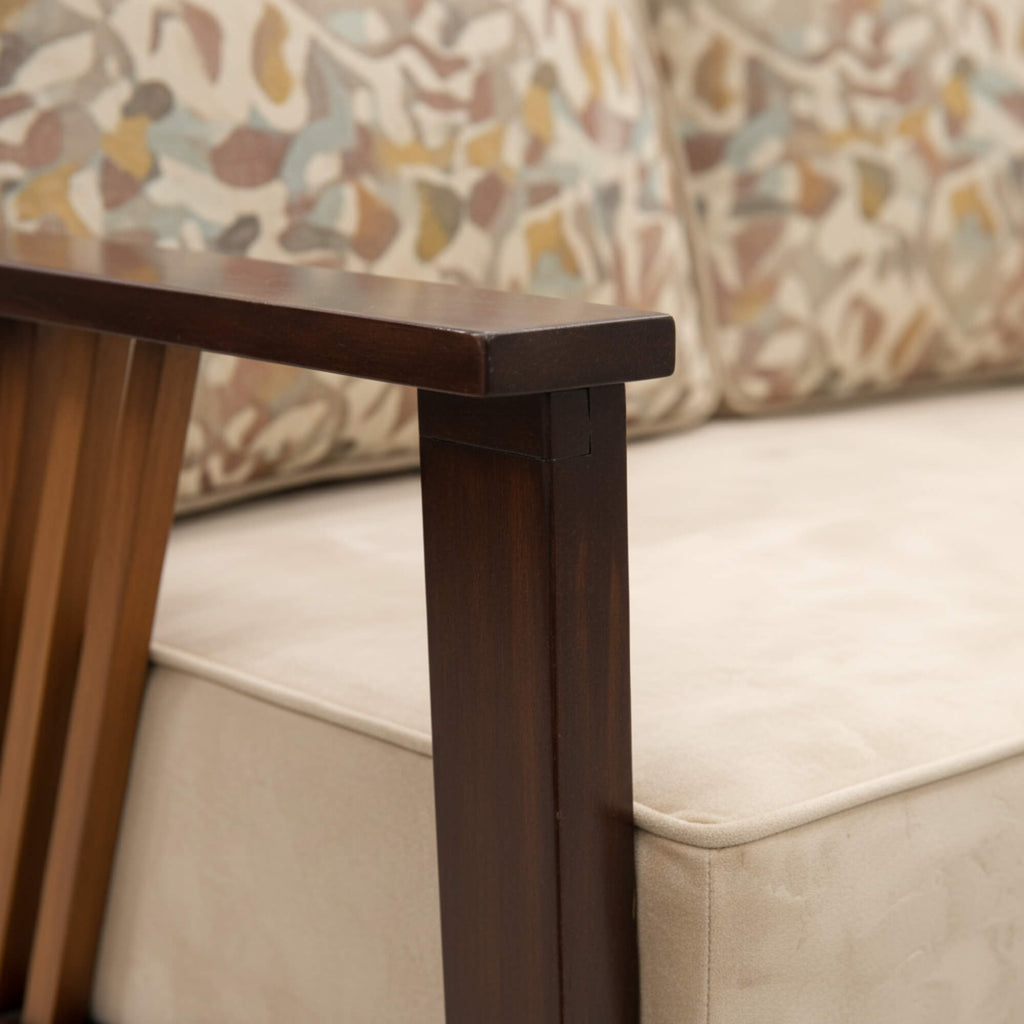 Wooden table leg with a beige sofa and patterned cushion in the background