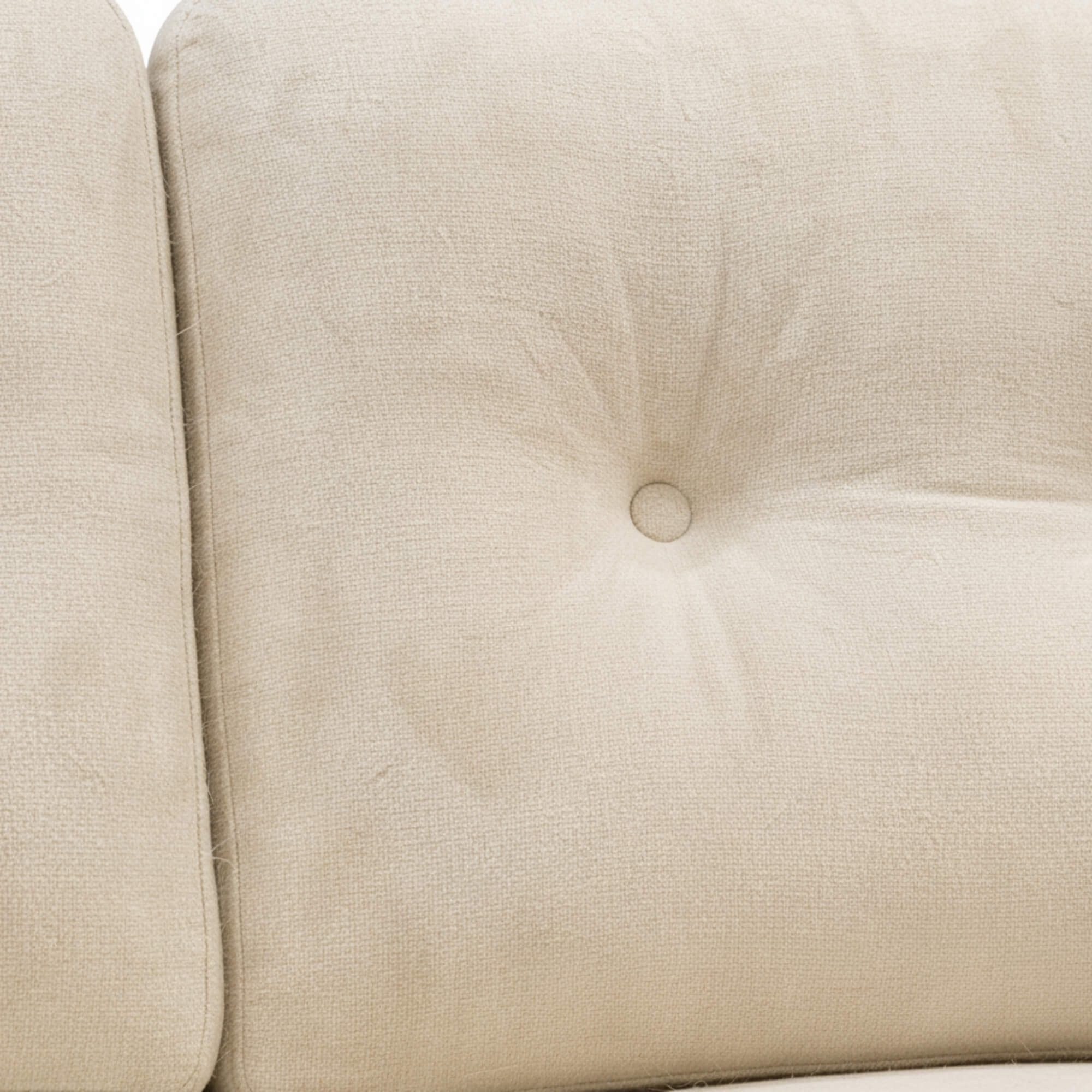 Close-up of a beige upholstered chair with tufted backrest