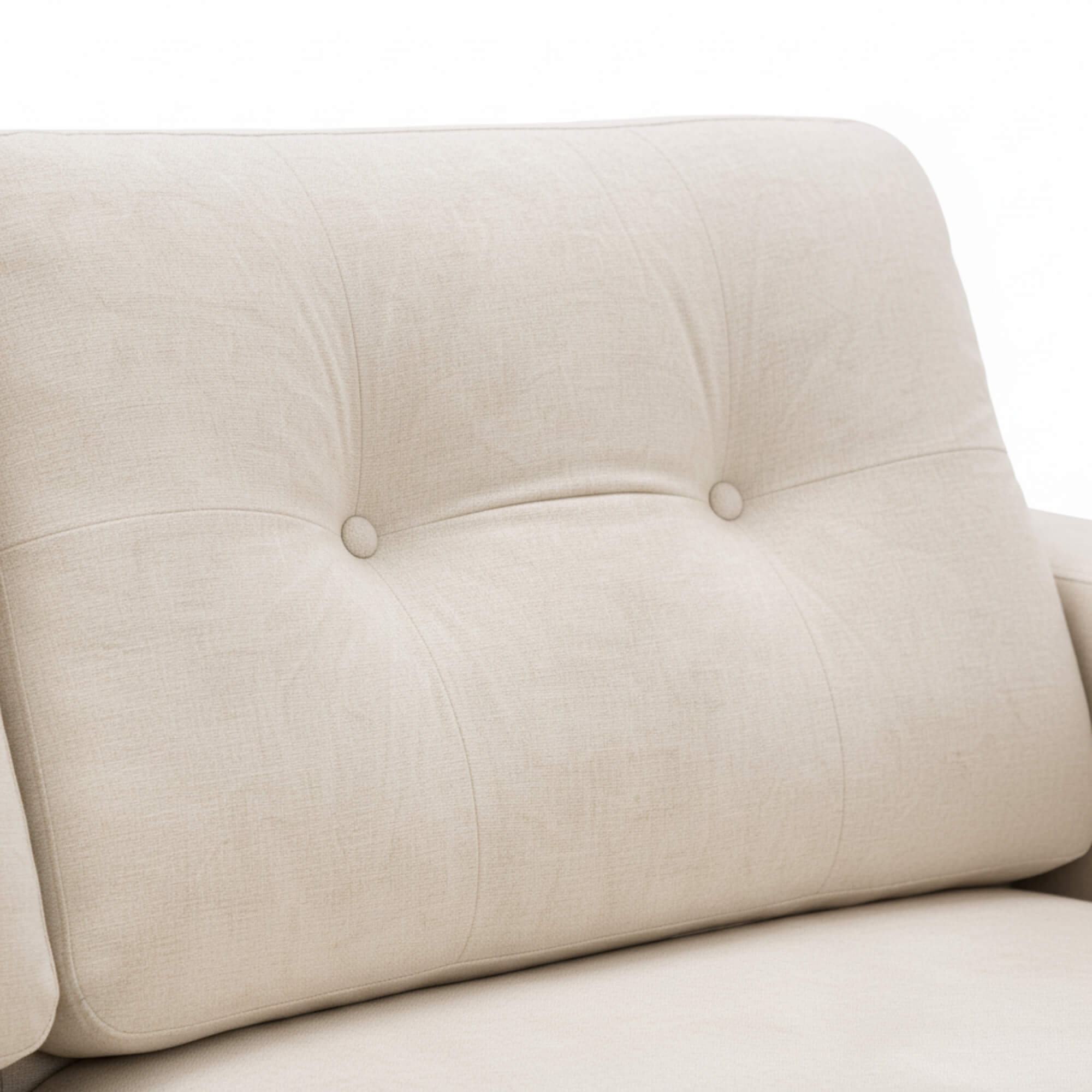 Close-up of a beige upholstered chair with button tufting on a white background