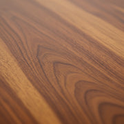 Close-up of a wooden surface with a rich, warm brown color and visible grain pattern.