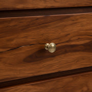 Close-up of a wooden drawer with a brass knob