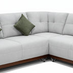 Gray sectional sofa with a green pillow on a white background