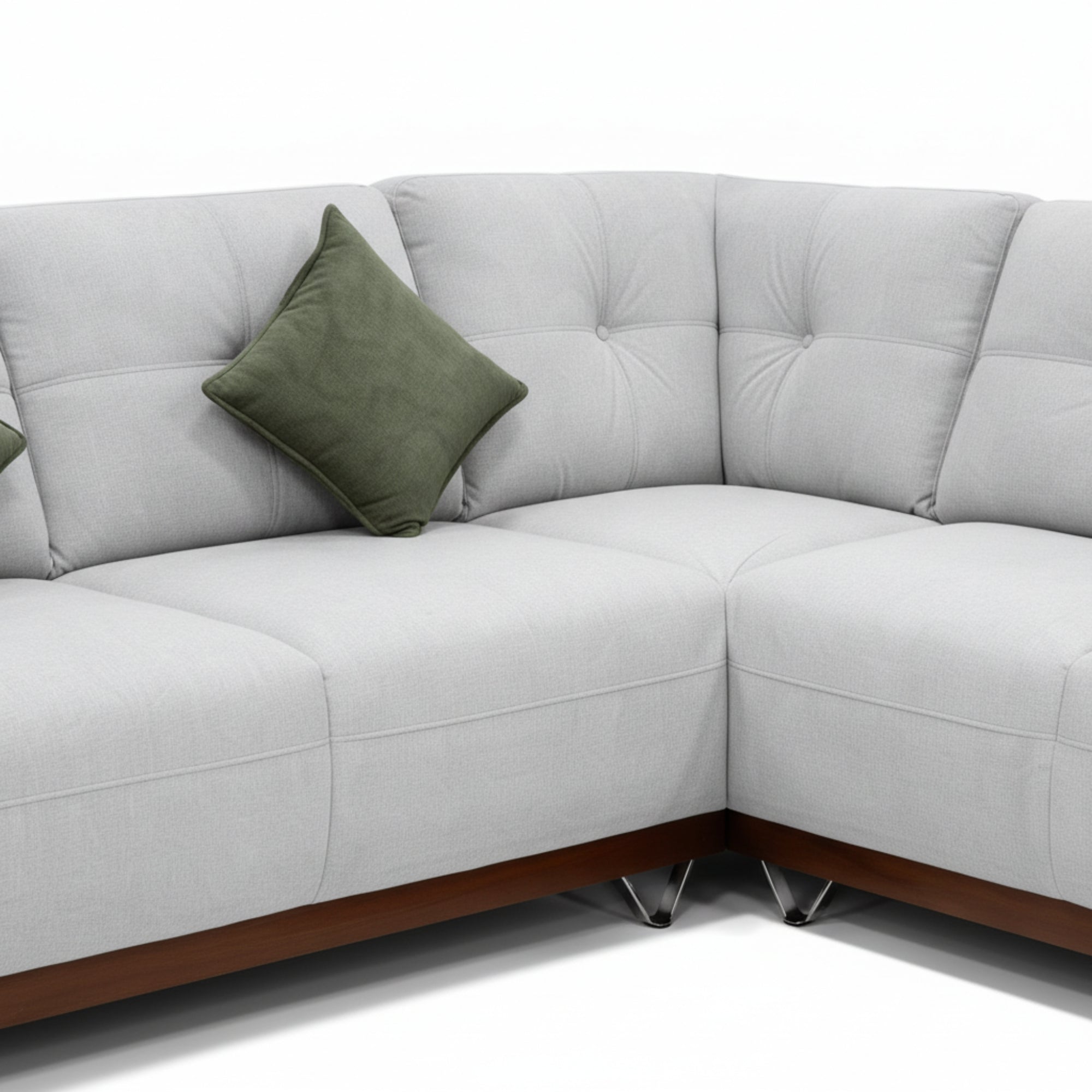 Gray sectional sofa with a green pillow on a white background