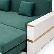 Green sectional sofa with gold accents on a white background
