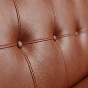 Close-up of brown leather upholstery with tufted design
