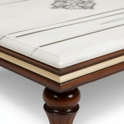 Close-up of a wooden table with marble-like surface and decorative element.