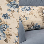 Floral-patterned fabric on a bed with blue headboard