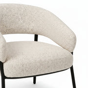 Modern chair with textured beige cushion and black frame on a white background