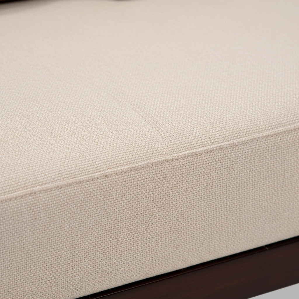 Close-up of a beige upholstered chair with a textured fabric surface.