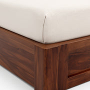 Wooden bed frame with a white mattress on a white background