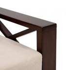 Close-up of a dark brown wooden chair leg with a beige cushioned seat on a white background