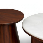 Two round tables, one wooden and one with a white surface, on a white background.