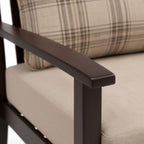 Close-up of a chair with plaid cushion and wooden armrest.