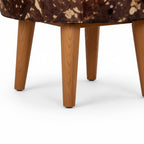 Close-up of a brown and white patterned chair with wooden legs on a white background
