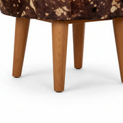 Close-up of a brown and white patterned chair with wooden legs on a white background
