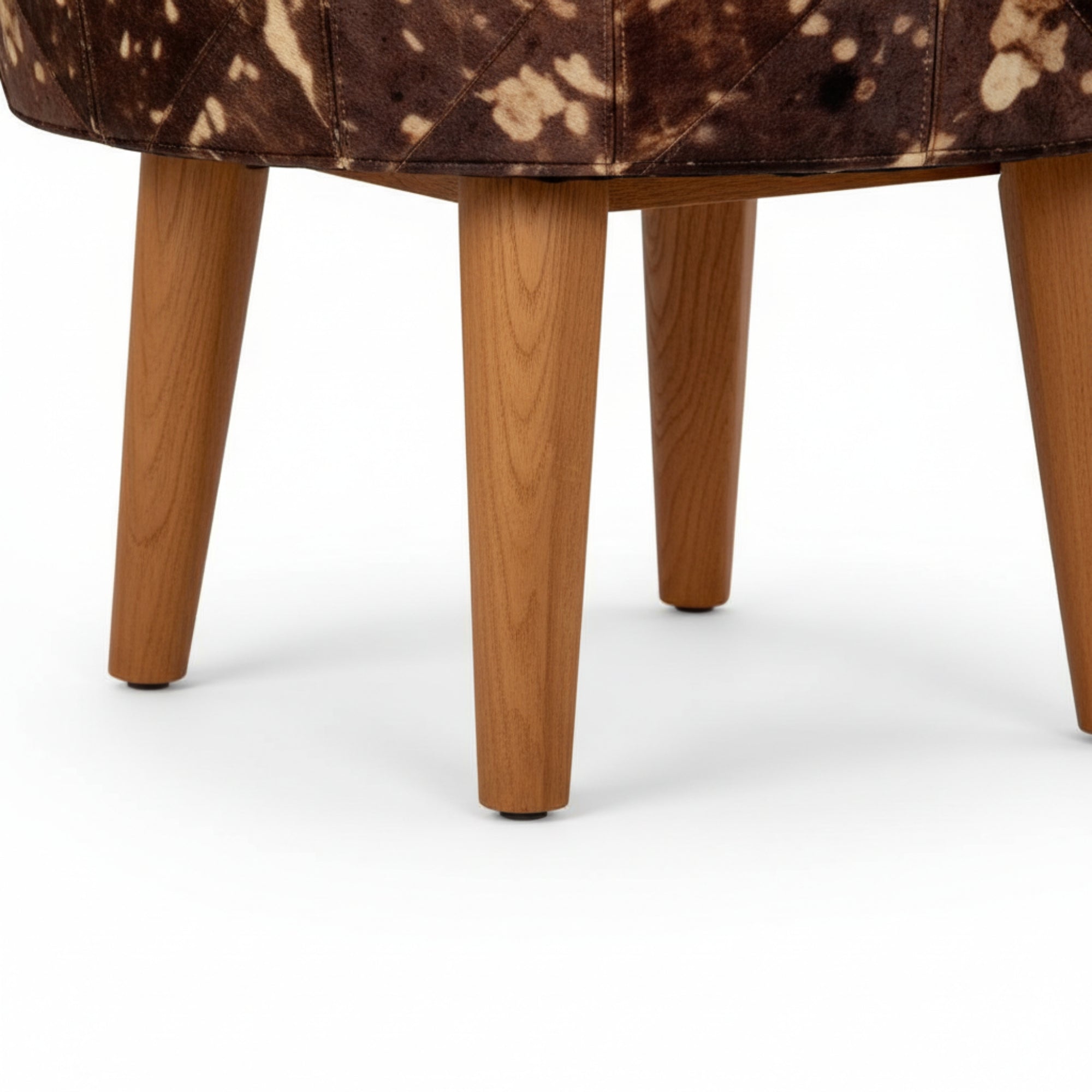 Close-up of a brown and white patterned chair with wooden legs on a white background
