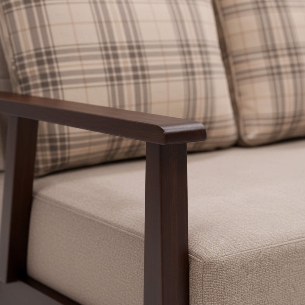 Close-up of a sofa with plaid patterned cushions and wooden armrest.