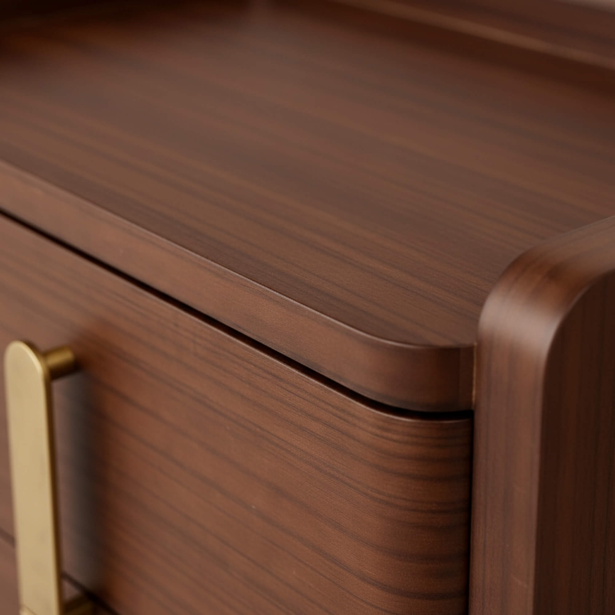 Close-up of a wooden drawer with a gold handle