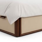 Beige bed frame with white bedding on a light background