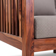 Close-up of a wooden chair with gray cushioned seat