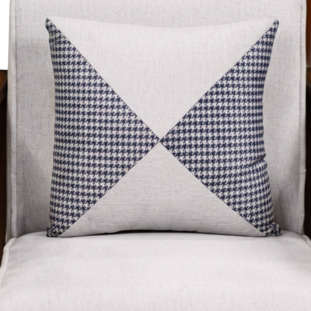 Decorative pillow with blue and white geometric pattern on a gray background