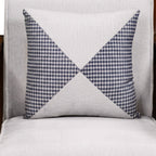 Decorative pillow with blue and white geometric pattern on a gray background