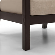 Close-up of a chair leg with a beige cushion on a white background