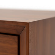 Close-up of a wooden cabinet corner with a neutral background