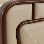 Close-up of a beige upholstered chair with brown wooden armrests.
