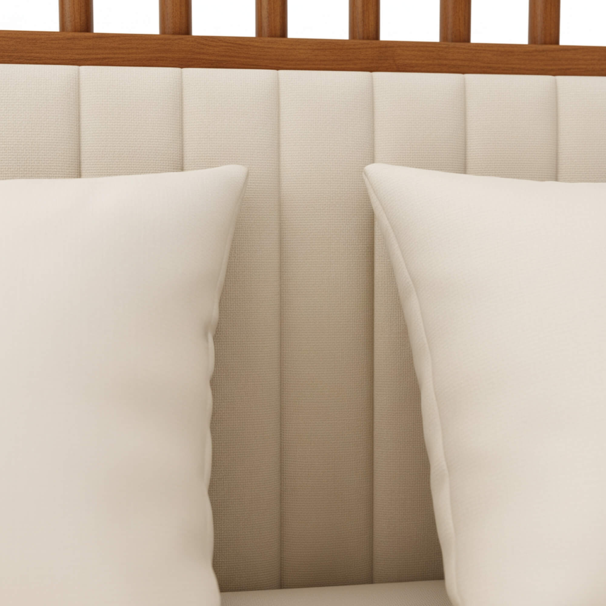 Two pillows on a bed with a wooden headboard and beige upholstered headboard.