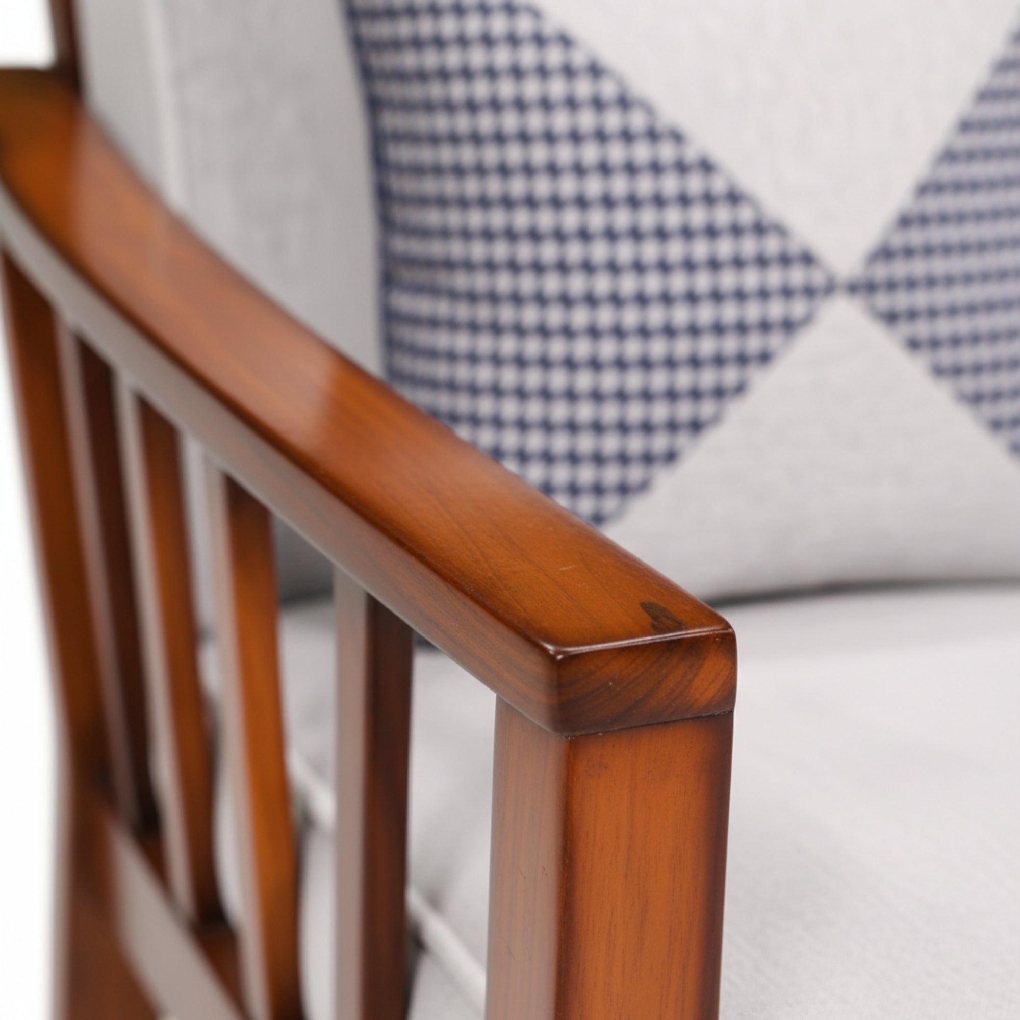 Close-up of a wooden chair armrest with a blurred background