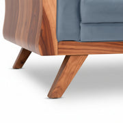 Sofa with wooden legs and blue cushion on a white background