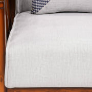 Gray cushion on a wooden chair with a checkered pillow.